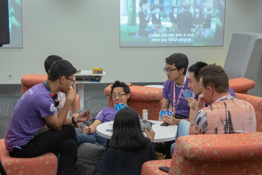 2026 20 A group of volunteers sit around a table, playing the card game Hanabi